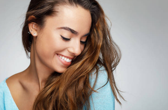 Side view of woman with long brown hair smiling