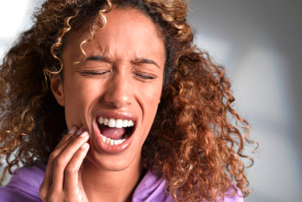 Woman holding her mouth in pain because of toothache