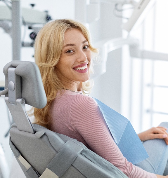 Patient smiling while sitting in treatment chair