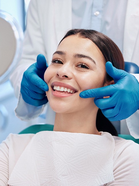 Patient smiling while holding small mirror